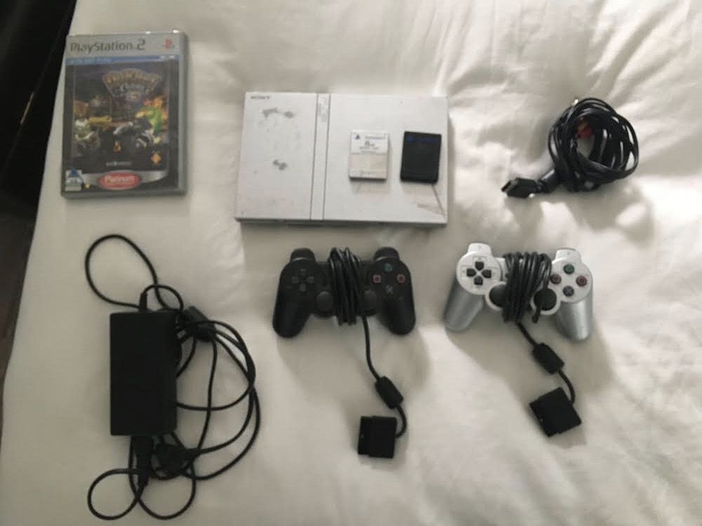 PlayStation 2, with controllers and game 