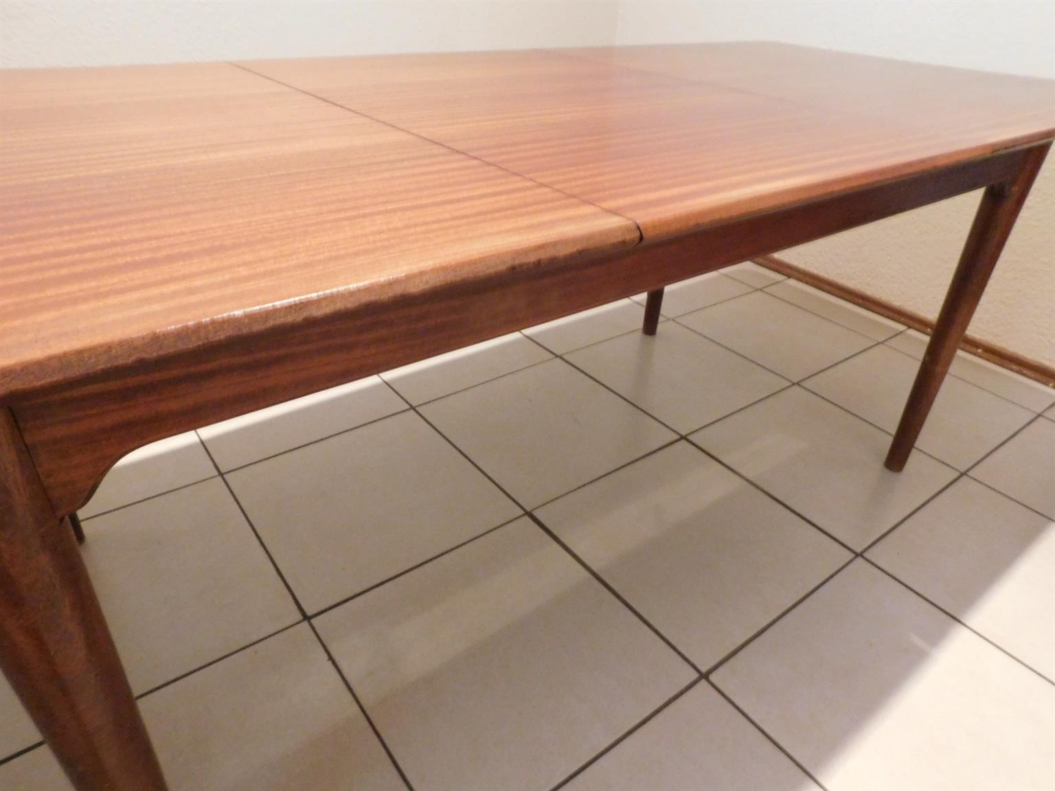 A beautiful, Imbuia, 8 seater dining room table with a fold-under extension.