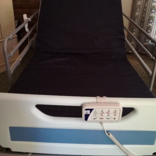 Hospital/ICU bed with overbed table and anaesthetic trolley with drawer
