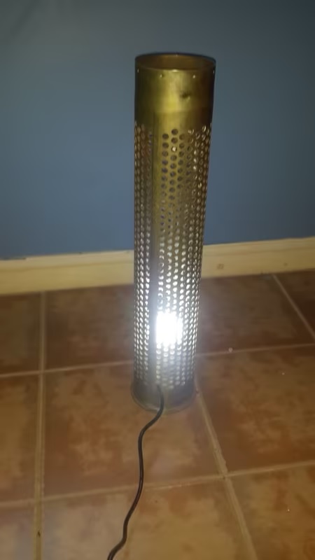 Ordnance shell repurposed to a standing light in good condition.