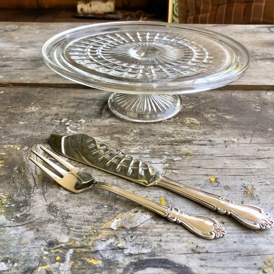 Large Vintage clear pressed glass cake stand with a silver plated cake knife and fork. Large Vintage clear pressed glass cake stand with a silver plated cake knife and fork.