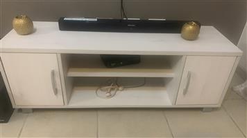 Second hand 2 seater orange couch and a new tv stand for sale 