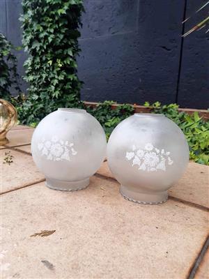Vintage glass items are frosted ball-shaped lamp shades featuring etched floral pattern. 