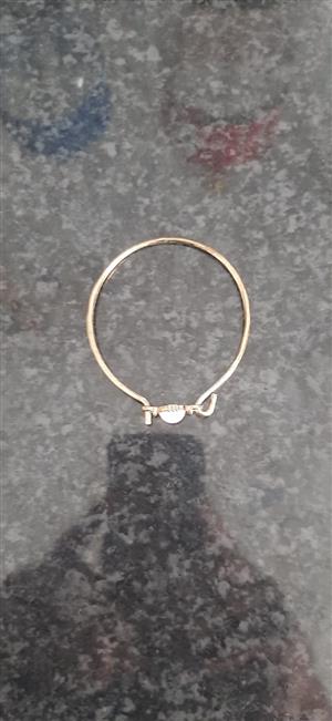 Gold-toned bangle bracelet with a clasp closure.