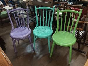 Three, brightly coloured kitchen chairs