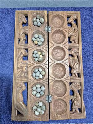 Vintage handcrafted wooden Mancala board, a traditional strategy game popular across Africa