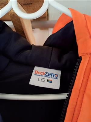 A orange and black Bevk Zero thermal jacket with reflective strip.al jacket