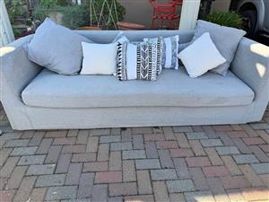 Modern Grey curved couch with scattered cushions