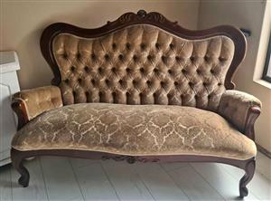 Victorian walnut sofa dark wood frame with ornate carved details and button-tufted upholstery