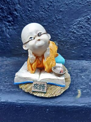 Vintage hand painted figurine of a young Shaolin monk reading a book