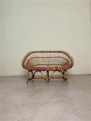 Vintage cane loveseat bench with a sculptural, rounded design 