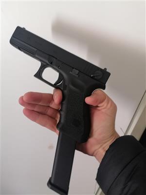 Glock airsoft pistol with extended mag