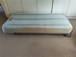 2x single bed springed bases including wheeled metal frameworks