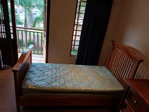 Single solid wood bed with headboard and mattress.