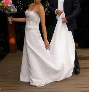  This wedding dress is a strapless, white A-line gown featuring a fitted, subtly