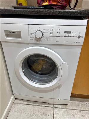 white Siemens iQ300 front-loading washing machine . 