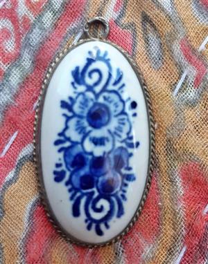 Genuine hand-painted Delftware pottery from Netherlands. The setting is crafted from 835 silver