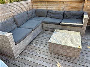 L- shaped grey rattan outdoor couch with small table.  Collection in Seapoint