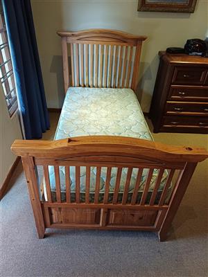 Single solid wood bed with headboard and mattress.