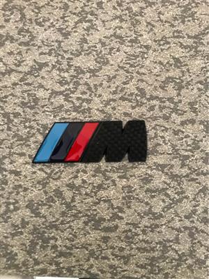 M badge