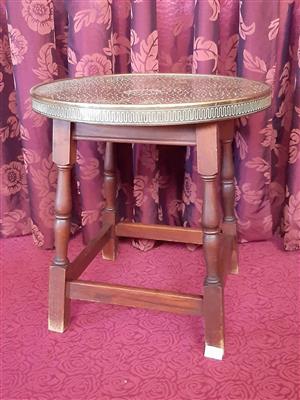 Round occasional table, metal top, brass-toned gallery rim, stretcher base.