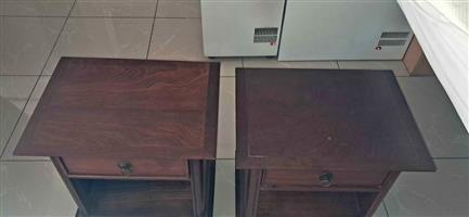 A pair of dark wood bedside pedestals featuring a single drawer and an open lower shelf. MAHOGANY