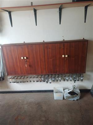 Two door tool cabinet with lots of tools like hammers, chisels, all sorts screw 