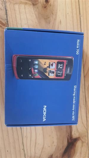 Nokia 700 in box with charger and ear phones. Battery still new. 