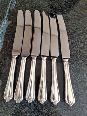 Vintage set (6) of silver-plated dinner knives with detailed decorative handles.