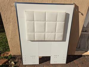 A white upholstered headboard for kids bed with a tufted, square-patterned desig