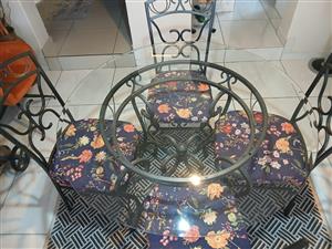 A round glass top dining/patio table with 4 matching chairs...