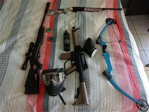 Black pellet gun with a Daisy and a crossbow as well as a paintball gun 