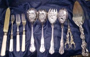 collection of vintage and antique silver-plated or bone-handled serving utensils,