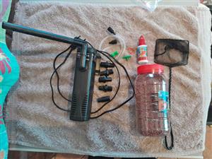 Submersible pump and components with net and fish food with water drops.