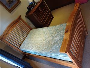 Single solid wood bed with headboard and mattress.