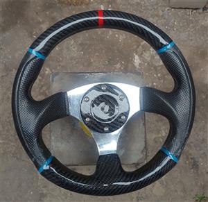 Sports steering wheel with 3k carbon fibre top and bottom of steering wheel