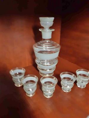 Vintage glass decanter set with five matching shot glasses.