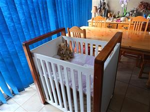 Babies cot made from pine with a cherry wood frame